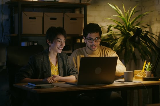 Colleagues seeing a laptop screen assessing their company on AI systems BR