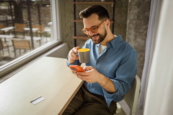 Man using smart phone and credit card for online shopping at cafe
