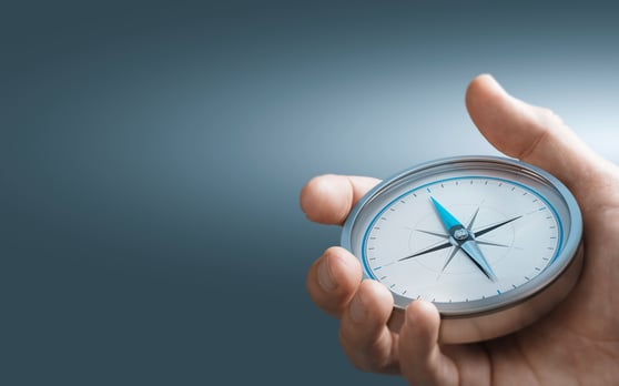 Hand holding a compass