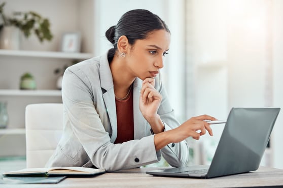 Serious, professional businesswoman sitting and seeing a laptop
