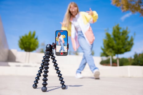 Young woman making a TikTok video, illustrating the concept of trend vs fad in social media content creation.