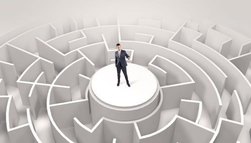 Person standing in the middle of a maze, looking for direction.