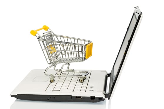 Graphic of shopping cart on top of a laptop keyboard.