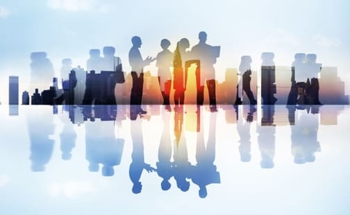 Image of people and their shadows standing in front of a skyline.