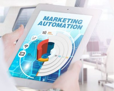 Graphic of a person holding a tablet, which says Marketing Automation on the screen.