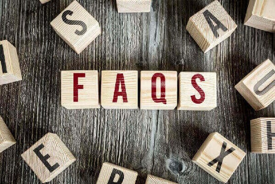Wooden blocks on a grey table with the word FAQs.