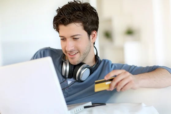 Young-man-buying-music-on-internet-with-tablet