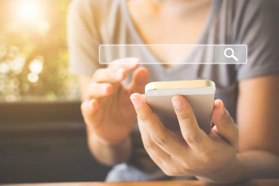 Women using a smartphone with a search bar overlaid.