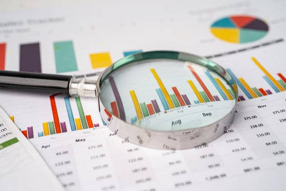 Magnifying glass on charts graphs paper. 